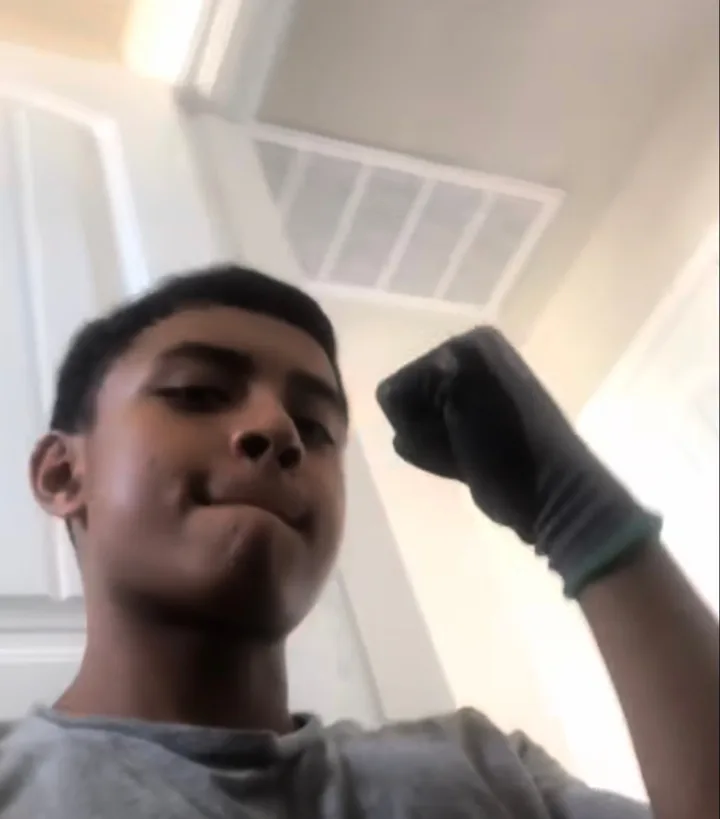 Christian as a young plumber's helper, wearing work gloves and holding up a fist